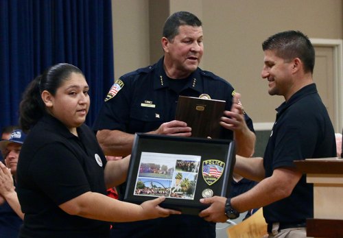 Lemoore Chief of Police Darrell Smith honors Jasmine Gomez (left) and Officer Jason Stephens (right) for their work on Lemoore's lip sync challenge video.